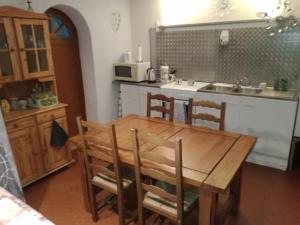 cocina con mesa de madera con sillas y fregadero en studio chez l'habitant en Pierrelatte