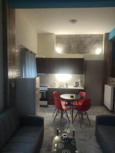 a living room with a table and chairs and a kitchen at GCM 2 ROOMS kentro in Katerini