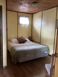 1 dormitorio con 1 cama grande y ventana en Cabaña la Solar., en Frutillar