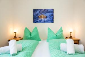 2 camas en una habitación con almohadas verdes en Haus Herz, en Haus im Ennstal