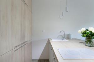 a kitchen with a sink and a vase of flowers at Elite Apartments Rezydencja Wintera in Gdańsk