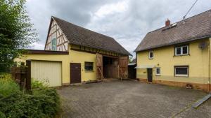 een geel huis met een garage en een gebouw bij Bauernhaus zwischen Rheingau und dem Taunus in Schlangenbad