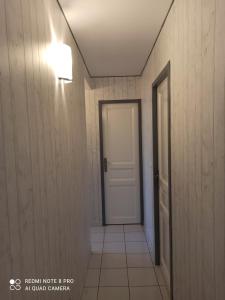 a hallway with a white door and a tile floor at Chambre d hôte à 20 min de VERSAILLES in Le Mesnil-Saint-Denis