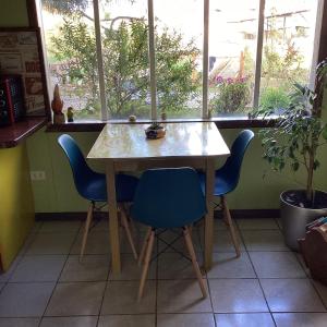 mesa y sillas en una habitación con ventana en Cabaña la Solar. en Frutillar
