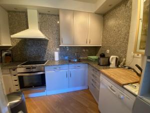 a kitchen with white cabinets and a stove top oven at Fontargent -2C Soldeu in Soldeu