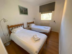 twee bedden in een kleine kamer met een raam bij FONTARGENT 3 in Soldeu