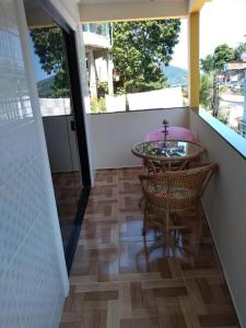 a room with a balcony with a table and chairs at Casa familiar in Angra dos Reis