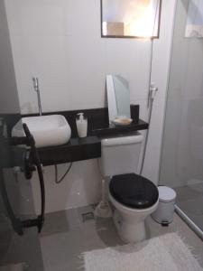 a bathroom with a black toilet and a sink at Casa familiar in Angra dos Reis