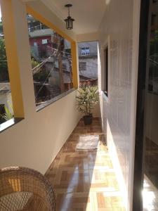 a hallway with two chairs and a potted plant at Casa familiar in Angra dos Reis