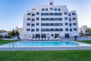 马贝拉Aqua Apartments Bellamar, Marbella的一栋建筑前有一座游泳池