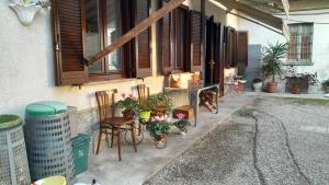 a porch of a house with chairs and flowers at Lo sciuro in Busto Arsizio
