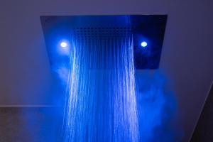 doccia blu con tenda e due luci di Profumi di Primavera Luxury Rooms a Matera