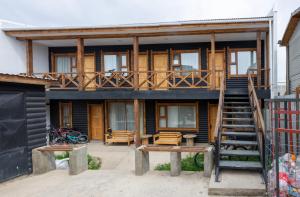a wooden house with a staircase in front of it at Natagonia Apartments in Puerto Natales