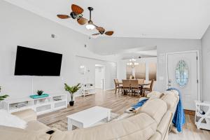 a living room with white furniture and a flat screen tv at Blue Lagoon in Tampa