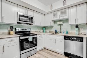 a kitchen with white cabinets and a stove and microwave at Blue Lagoon in Tampa