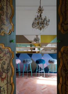 a bar with stools in a kitchen with a chandelier at Palazzo Luce in Lecce