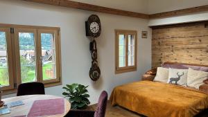 1 dormitorio con 1 cama y reloj en la pared en Romantic private superior Swiss Chalet with Hottub, en Lungern