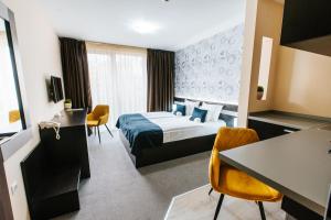 ein Hotelzimmer mit einem Bett, einem Tisch und Stühlen in der Unterkunft Hotel Auris in Szeged