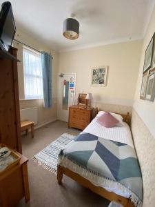 1 dormitorio con 1 cama, vestidor y TV en Buckingham Lodge Guest House, en Torquay