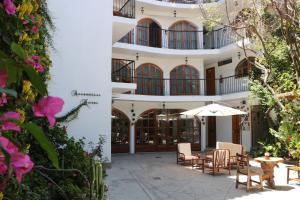 ein Gebäude mit einer Terrasse mit Stühlen und einem Sonnenschirm in der Unterkunft Astromelia Hotel in Ayacucho