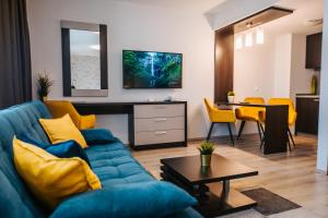 a living room with a blue couch and a table at Hotel Auris in Szeged