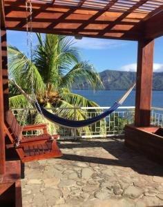 a hammock on a patio with a view of the ocean at Alchemy on the Lake in La Laguna
