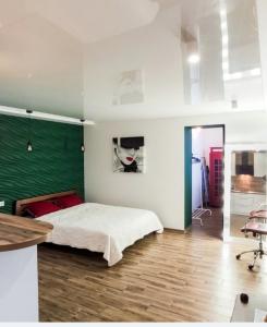 ein Schlafzimmer mit einem Bett und einer grünen Wand in der Unterkunft Studio Apartment Center in Krementschuk