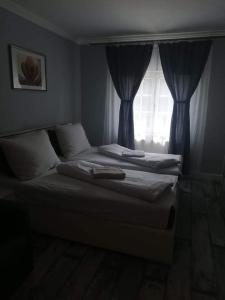 a bedroom with a bed and a window with curtains at Twins in Hurbanovo