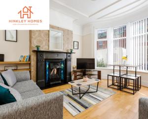 a living room with a couch and a fireplace at Supersized 5bed - Free parking - 8 beds - Anfield - By Hinkley Homes Short Lets & Serviced Accommodation in Liverpool