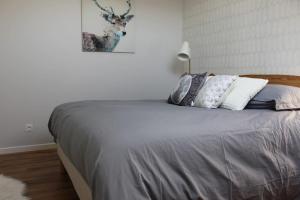 una camera da letto con un letto con cuscini sopra di T4 Meublé de 105m2 axe Annecy-Geneve a Saint-Martin-Bellevue