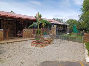 a patio with a fire pit in front of a house at KHAYA LANGA Guest House & Contractors Accommodation in Machadodorp