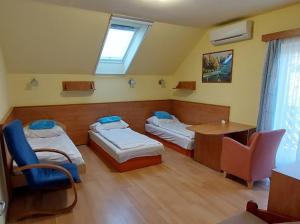 a room with two beds and a table and chairs at Zöld Zóna Zamárdi Üdülő in Zamárdi