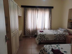 Machadodorp的住宿－KHAYA LANGA Guest House & Contractors Accommodation，小房间设有两张床和窗户