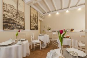a restaurant with white tables and chairs and flowers at La Residenza del Sole al Pantheon in Rome
