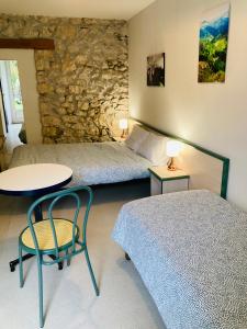 een slaapkamer met 2 bedden en een tafel en een stoel bij Le Jorjane in Choranche