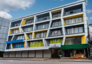 un edificio de apartamentos con ventanas amarillas y azules en KINGS CALICUT en Kozhikode