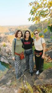 grupa trzech kobiet stojących na szczycie góry w obiekcie The Mountain View Home Stay w mieście Khajuraho