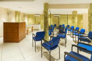 une rangée de chaises bleues dans une salle d'attente dans l'établissement KINGS CALICUT, à Kozhikode