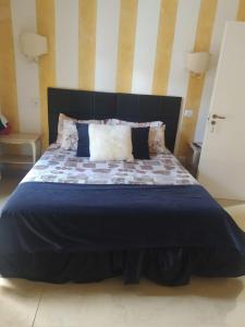 uma cama grande com um edredão azul e almofadas em FiumicinoA57 em Fiumicino
