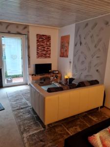 a living room with a couch and a tv at Wald und Felsen - Apartment in Ludwigswinkel