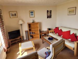 a living room with a couch and a tv at Links Quay 42 in Prestwick