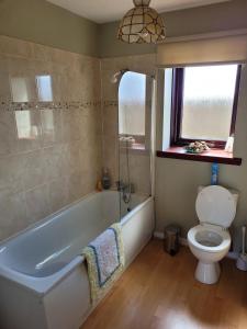 a bathroom with a tub and a toilet and a window at Links Quay 42 in Prestwick