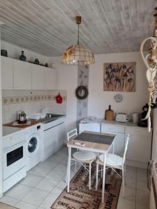 a kitchen with white cabinets and a table and chairs at Wald und Felsen - Apartment in Ludwigswinkel