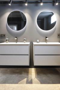 a bathroom with two sinks and two mirrors on the wall at MAESTRANZA MODERN y LUXURY in Seville