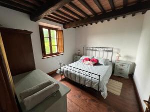 a bedroom with a bed with pink pillows on it at Villa Casa di Pietra en el norte de Lucca, Toscana in Camporgiano +39 photos