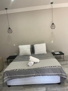 a bed with two pillows and a stuffed animal on it at Guest house on Gillian Unit 7 in Ballito