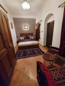 uma sala de estar com uma cama e uma mesa em Riad dar Karam em Marrakech