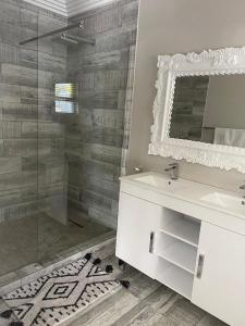 uma casa de banho com um lavatório e uma cabina de duche em vidro. em Guest house on Gillian Unit 7 em Ballito