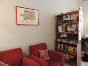 a living room with a red couch and a book shelf at B&B Bonapace Portanolana in Naples