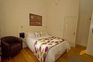 a bedroom with a bed and a chair at Meals Farm - Courtyard Room in North Somercotes +9 photos